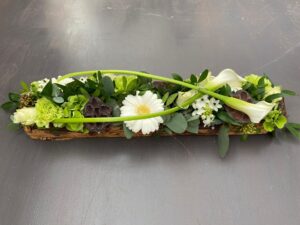 Allerheiligen bloemstuk met gekleurde tinten en bananenblad