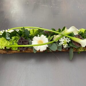 Allerheiligen bloemstuk met gekleurde tinten en bananenblad