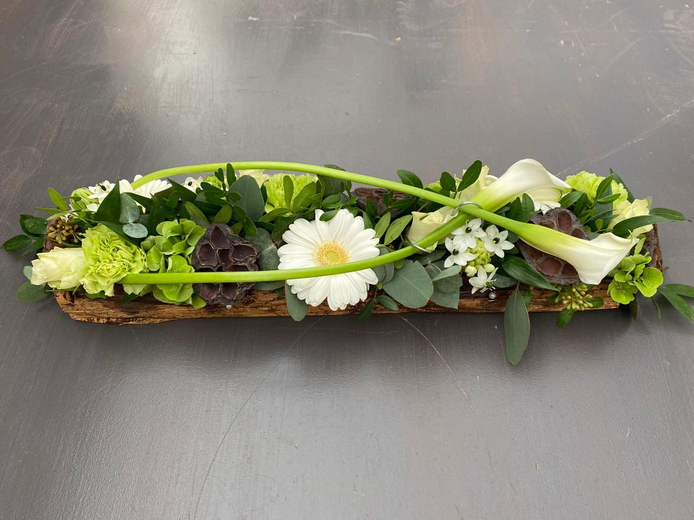 Allerheiligen bloemstuk met gekleurde tinten en bananenblad